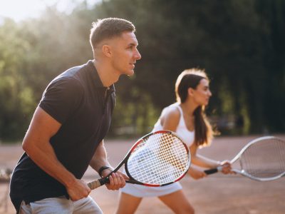 Young couple playing tennis at the court